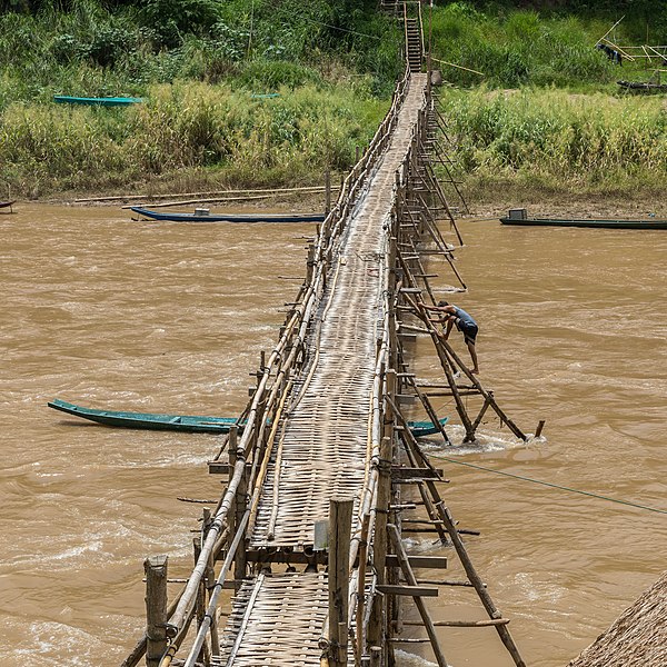 File:Wooden footbridge in Luang Prabang with a worker busy at its consolidation.jpg