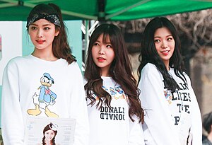 Image of Orange Caramel members wearing white sweaters with Donald Duck pictures on them