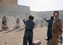 An RCMP constable and instructor, observing Afghan National Police members as they shoot at targets in Kandahar, 2010 ANP officers and leaders move toward self-sufficiency DVIDS347312.jpg