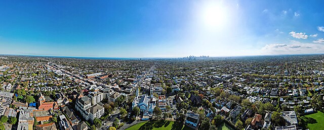 Aerial panorama of Malvern facing west towards the Melbourne skyline and Port Philip Bay. April 2023.
