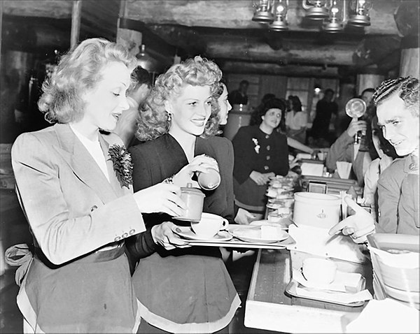 Dietrich and Rita Hayworth serve food to soldiers at the Hollywood Canteen (17 November 1942).