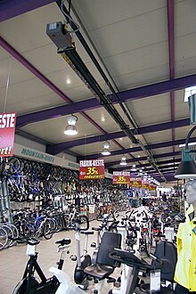 Bicycles and exercise equipment for sale inside a local bike shop Fahrradverkaufsraum.jpg