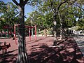 L'ancien square avec son sol de caoutchouc anti-chute et ses jeux avec vue sur la butée et la statue d'Yves Montand. L'accès à la butée était interdit et empêché par une barrière, visible sur la photo. Aujourd'hui, si c'est toujours le cas, un chemin a été creusé dans la butée, permettant de rejoindre l'autre côté de la place en passant entre les quatre néfliers.