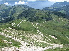 Die Südseite mit der zum Rifugio führenden Schotterstraße, im Hintergrund die Corna Piana und der Einschnitt des Etschtales