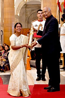 Man presents award——to woman.