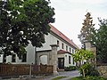 Wohnstallhaus, Seitengebäude und Scheune eines Dreiseithofes, dazu zwei Torpfeiler der Hofzufahrt und Gedenktafel am Haus