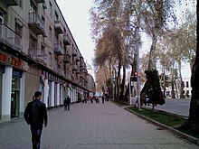 People walking down a very wide sidewalk on Rudake Avenue in Dushanbe