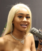 Saweetie (pictured) provides guest vocals on the album. Saweetie Atlanta June 2019.png