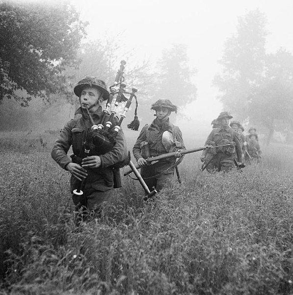 Led by their piper, men of the 7th Battalion, Seaforth Highlanders, part of the 46th (Highland) Brigade, advance, 26 June.