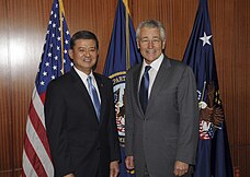 Former Secretary of Veterans Affairs, Eric Shinseki, and former Secretary of Defense Chuck Hagel at the Department of Veterans Affairs in Washington, D.C. The departmental flag is behind them, as well as the Secretary of Veterans Affairs flag, signifying the presence of the secretary. Secretary of Veterans Affairs Eric K. Shinseki and Secretary of Defense Chuck Hagel pose together for a picture during a meeting at the U.S. Dept. of Veterans Affairs in Washington, D.C..jpg