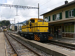 Gelbe Lokomotive vor zweistöckigem Gebäude