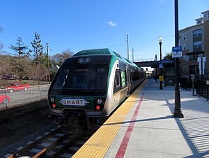 A green train at a railway platform