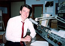 Former WTTF-AM-FM afternoon announcer Ken Hawk in 1994, taken in the main on-air studio at former 185 South Washington Street studio location. The DW-76 is seen just below microphone boom (gray panel with two switches). WTTF studio.jpg