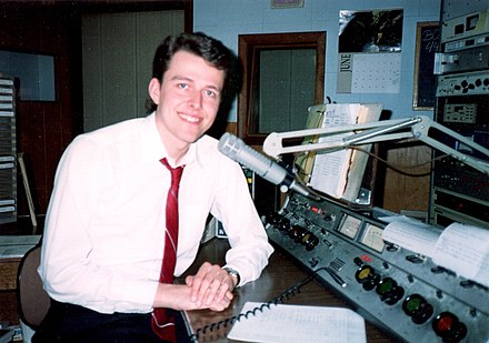 Former WTTF-AM-FM afternoon announcer Ken Hawk in 1994, taken in the main on-air studio at former 185 South Washington Street studio location. The DW-76 is seen just below microphone boom (gray panel with two switches).