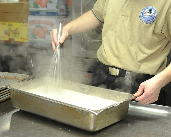 A chef whisking a sauce