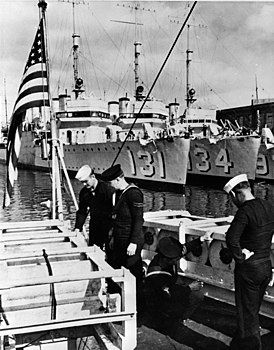 Des marins américains et britanniques sont aux grenades sous-marines.  En arrière-plan - destroyers américains de type "Vicks" transférés dans le cadre de l'accord "destroyers en échange de bases"