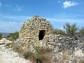 Vista frontal de una barraca de piedra en seco en Los Planos, Ademuz (Valencia), con detalle de muro.