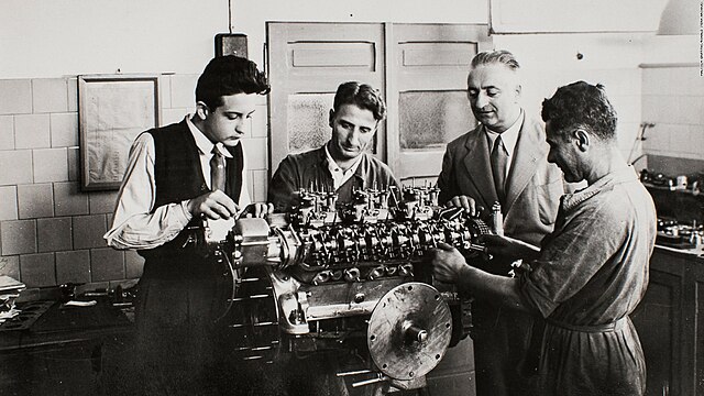 Enzo and Alfredo Ferrari, along with a pair of engineers, inspecting what is likely an early Colombo V12.