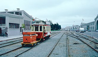 Belt Railroad tracks passing the Engine House in 1987, during a streetcar demonstration service that used the freight tracks for a short time 1987 SF Historic Trolley Festival - Porto 189 pushing generator cart on the Embarcadero.jpg