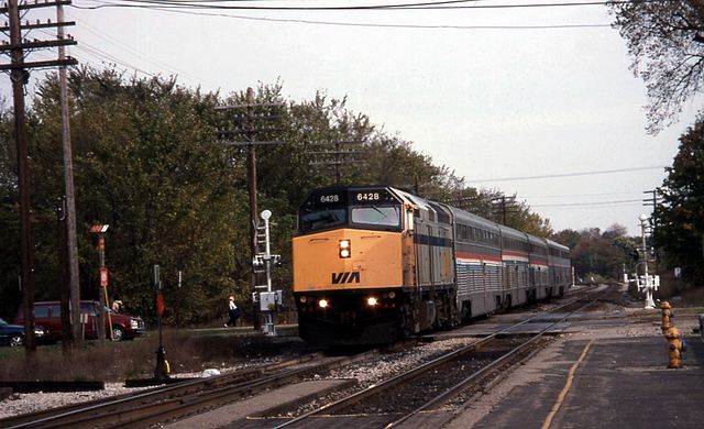 A Via Rail EMD F40PH leads the International with Amtrak Hi-Level and Superliner coaches into East Lansing in 1996
