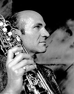 photo noir et blanc d'un homme chauve de profil avec un saxophone