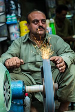 A worker sharpening the knives