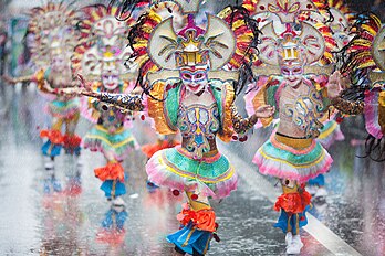 Festival Masskara, um festival anual realizado todo quarto domingo de outubro em Bacolod, Filipinas. O Festival começou em 1980 e apresenta uma competição de dança de rua onde pessoas de todas as classes sociais saem às ruas para ver dançarinos mascarados girando ao ritmo das batidas musicais latinas em uma demonstração de maestria, alegria, coordenação e resistência. O motivo da máscara do festival mudou de máscaras influenciadas pelos filipinos nativos para aquelas influenciadas pelo Carnaval de Veneza e pelo Carnaval do Rio de Janeiro. As máscaras anteriores eram pintadas à mão e adornadas com penas, flores e miçangas nativas, enquanto as máscaras contemporâneas apresentam miçangas de plástico e lantejoulas. (definição 5 400 × 3 600)