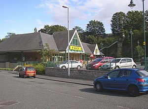 A supermarket building with cars parked outside