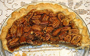 English: Half of a homemade pecan pie in a gla...
