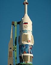 A Soyuz rocket with Olympic livery. Its flight to the International Space Station, TMA-11M, was part of Sochi's torch relay. Soyuz TMA-11M erected at Baikonur Cosmodrome (201311050027HQ).jpg