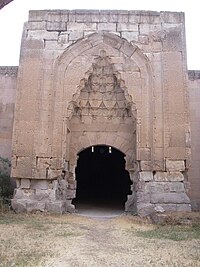 Una gran puerta de piedra con decoración tallada en piedra.