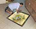 The handy man of the parish is cleaning old tile of St George