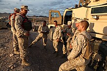 United States Marine Corps combat logistics personnel conversing before a patrol training exercise in 2012 U.S. Marines with Transportation Support Company, Combat Logistics Regiment 2, 2nd Marine Logistics Group, undergo realistic scenarios while executing a combat logistics patrol exercise during Enhanced Mojave 120922-M-KS710-001.jpg