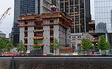 Construction of Three World Trade Center as of May 2012. A portion of the National 9/11 Memorial's South Pool can be seen in the foreground. WTC 3-May 2012.jpg