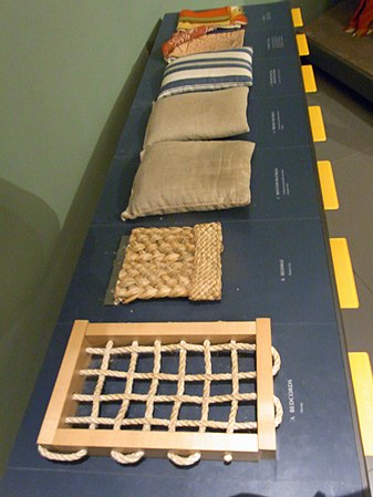 Touchable museum samples illustrating the layers of the Great Bed of Ware: the bedcords, a plaited-rush[8] bedmat, a flockbed and then a featherbed in dun ticking, a downbed in striped ticking, and the bedlinen.[4] Flock is unspun fibers, in this case probably wool. The bedticks stuffed with the softest fillings are laid topmost.