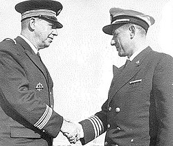 מפקד שייטת המשחתות אל"ם צבי קינן לוחץ את ידו של אדמירל קבנייה מהצי הצרפתי בהגעת שייטת המשחתות לנמל טולון, 1959.
