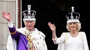 Rei e Rainha na varanda acenando