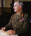 Fotografia colorida de retrato do Marechal de Campo Archibald Wavell em jaqueta de uniforme cáqui com coleira vermelha e faixas de medalhas de tecido