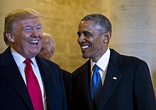 Obama and President Trump laughing together.
