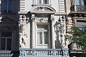 Detail of the facade, showing the ornate lampposts with putti