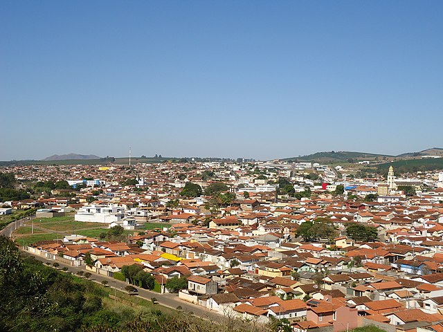 Vista de parte da cidade, com a Igreja Matriz Nossa Senhora da Ajuda à direita e, ao fundo à esquerda, a Serra de Três Pontas.