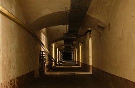 Dans le casernement principal. La partie métallique au-dessus du couloir est un conduit d'aération installé dans les années 1950 lors de la création de l'Ouvrage « G ».