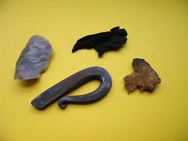 Typical contents of a tinder box. From left to right: flint, fire striker, char cloth and piece of mushroom.