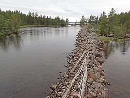 Eggelats södra utlopp med flottningsdammen i bakgrunden samt en ledarm av utrensad sten, avsedd att leda timret rätt.