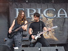 Deux guitaristes jouent de leur instrument sur une scène