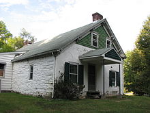 A view of the narrower side of the same house, which is otherwise similar to the front but with different windows.