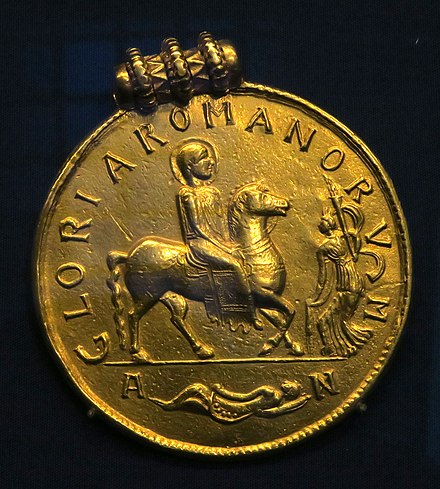 Medal of Valens showing the nimbate emperor on horseback, marked: gloria romanorum ("the Glory of the  Romans") Later set in a pendant and found in the Șimleu Silvaniei, a hoard from the second quarter of the 5th century (Kunsthistorisches Museum)