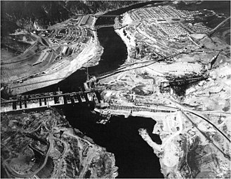 Baufortschritt an der Staumauer 1938, dahinter die Grand Coulee Bridge (Blick flussabwärts)