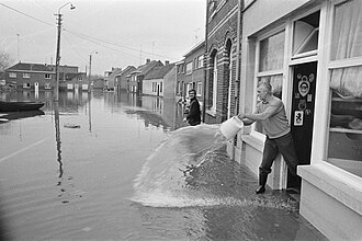 Flooding in Ruisbroek, January 1976 Herstel overstromingen in Belgie (Ruisbroek) op gang gekomen man leegt zijn hui, Bestanddeelnr 928-3599.jpg