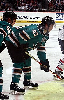 Foto van John McCarthy in de turquoise San José Sharks-trui.